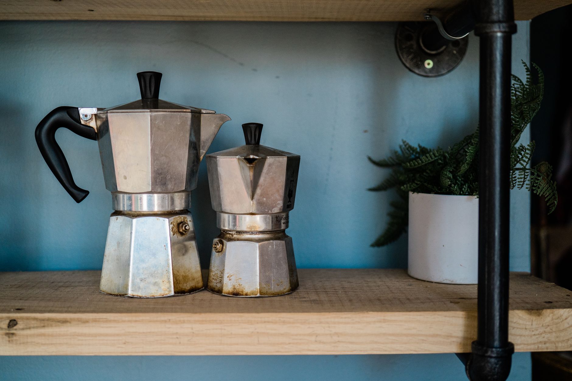 A row of different moka pot styles, from classic aluminum to modern steel