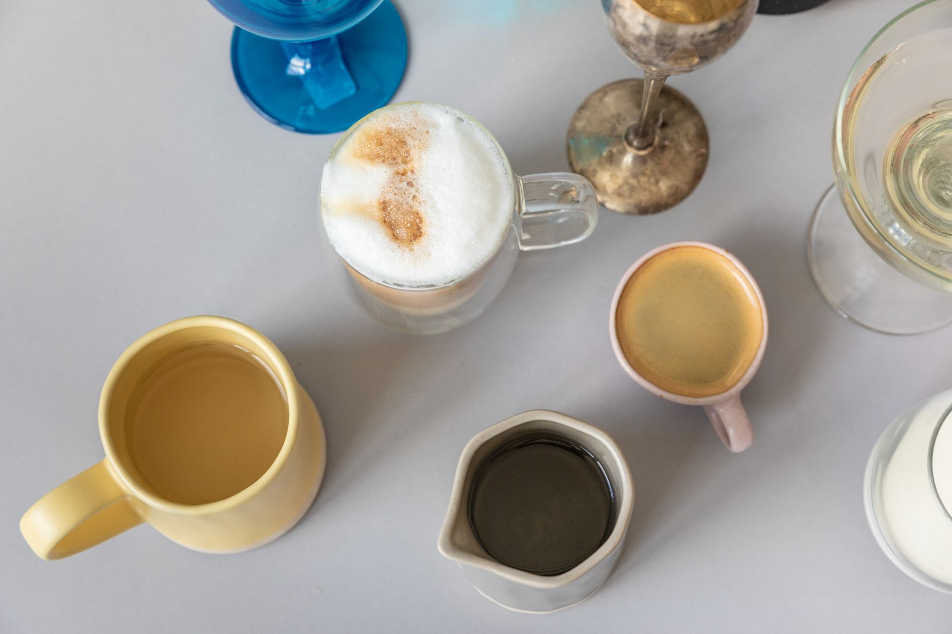 A small espresso cup next to a large mug of American drip coffee