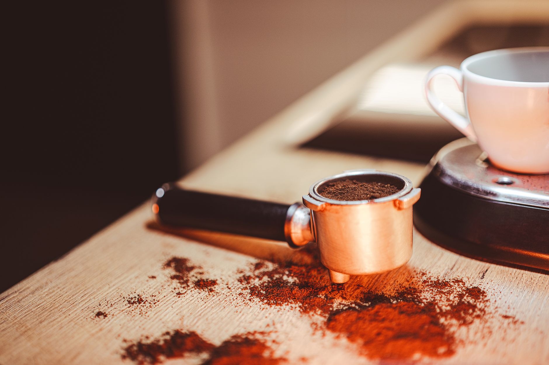 An overturned espresso cup on its saucer, with coffee grounds visible inside