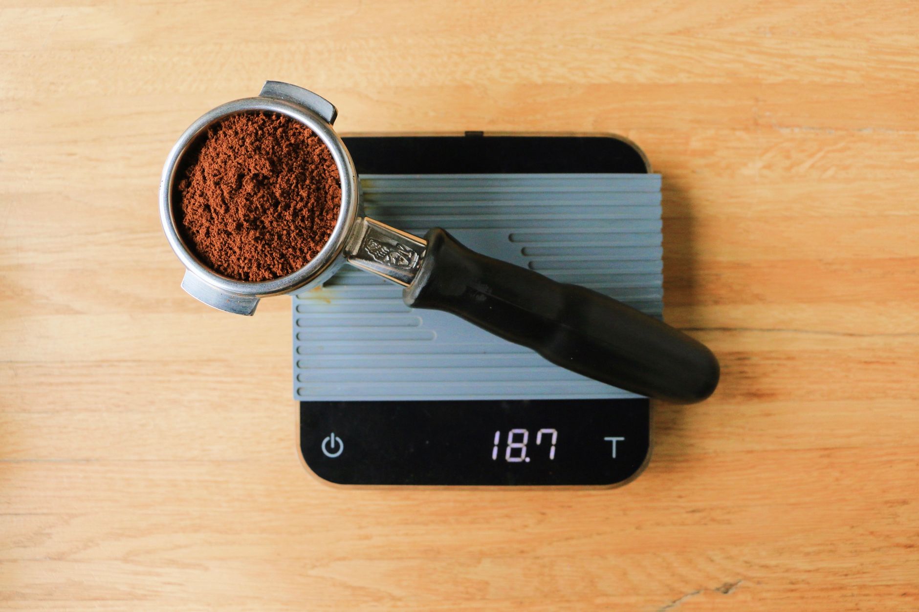 Ground coffee and a small scale next to a cuccumella filter basket