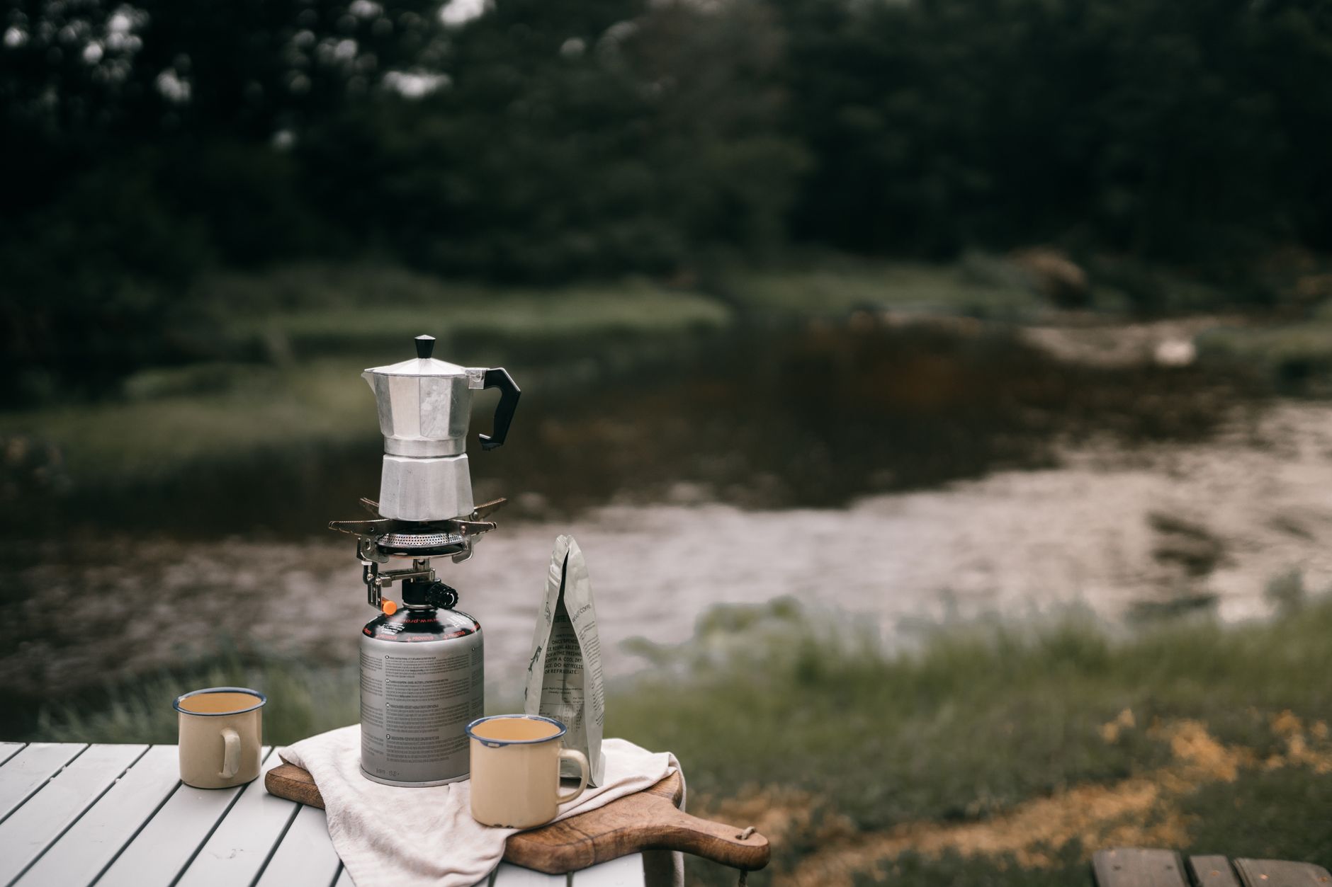 Bags of dark-roast Italian coffee next to a moka pot