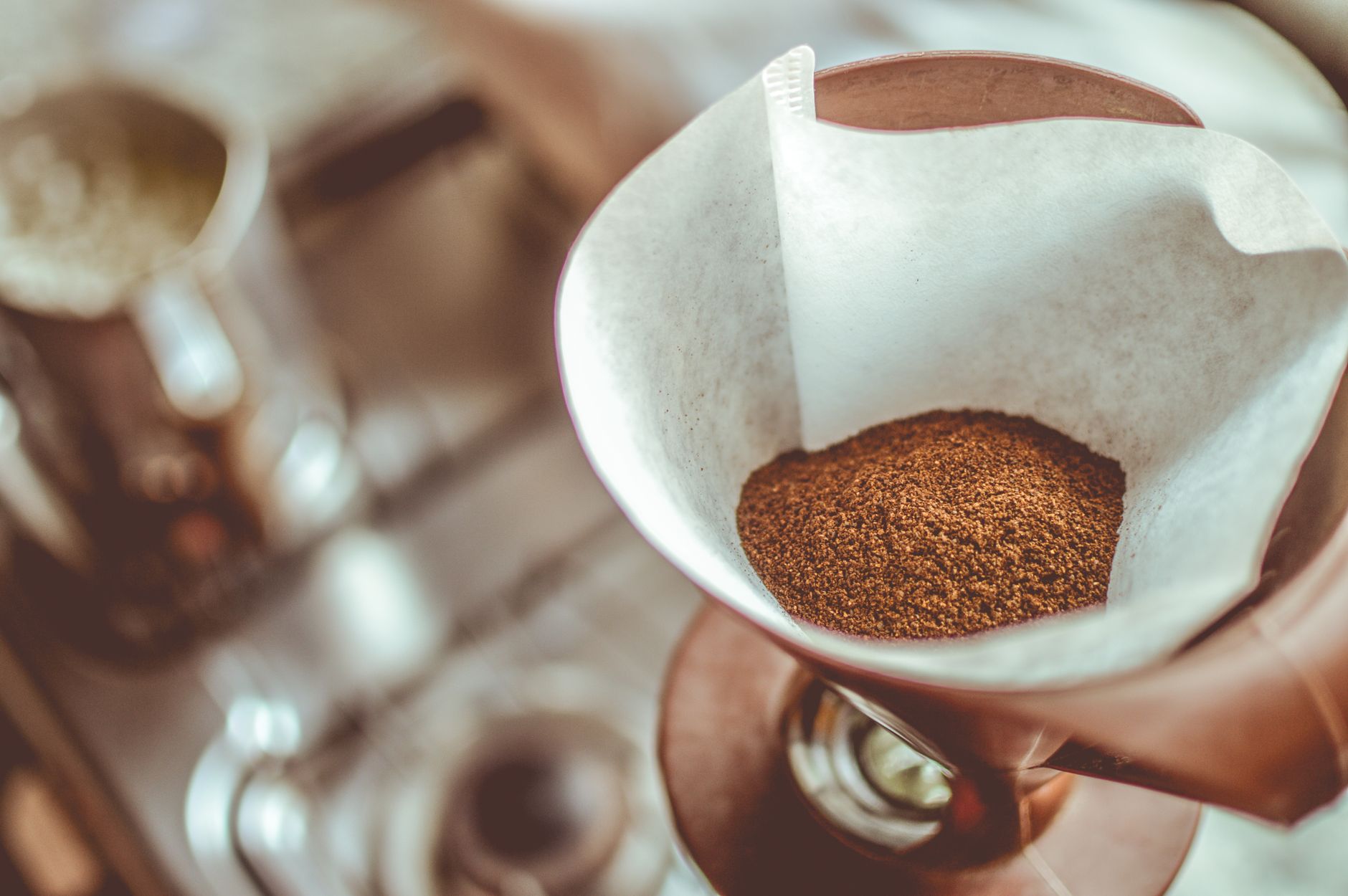Ground coffee filling a moka pot's funnel filter, leveled but not tamped