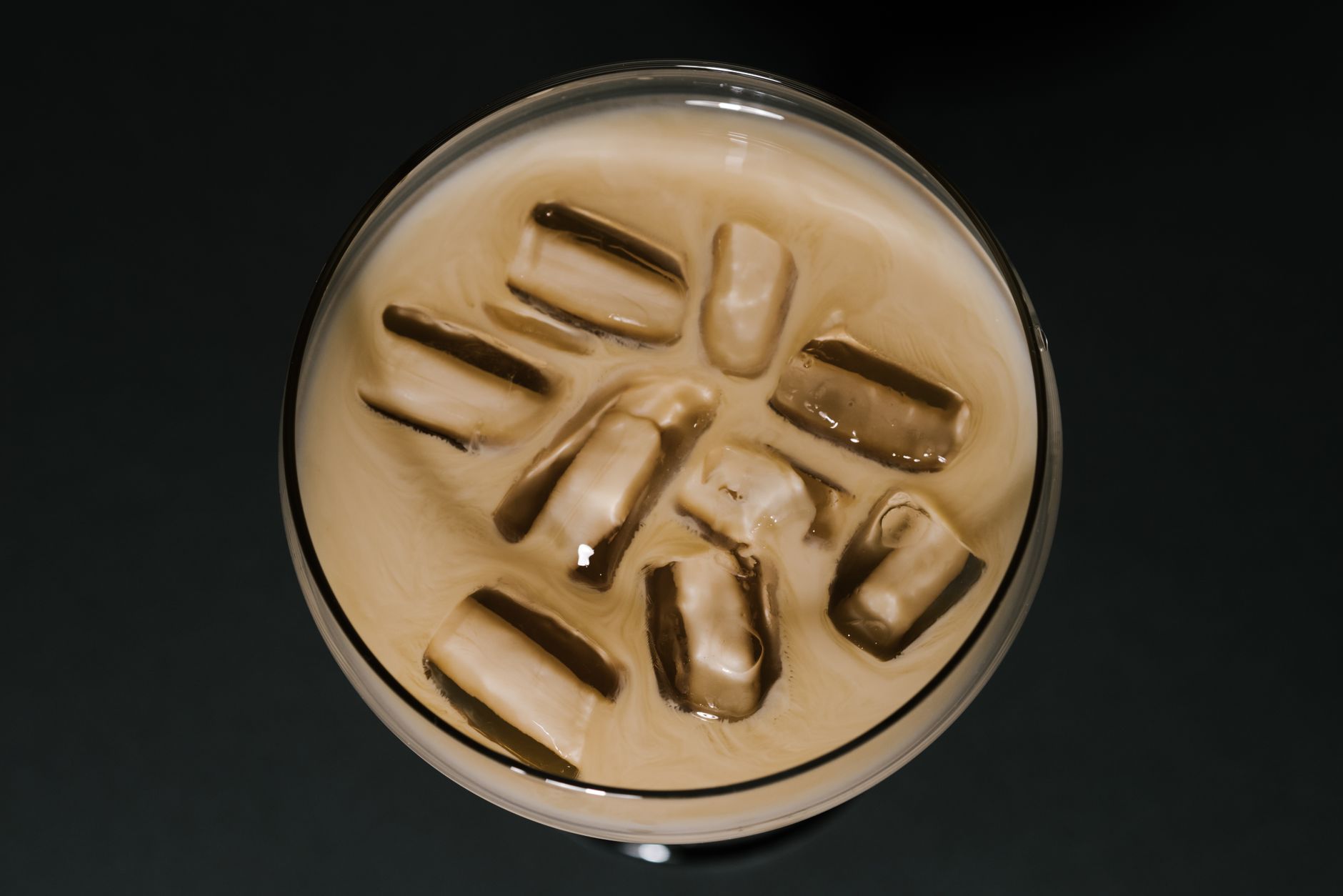 A small glass of creamy iced crema di caffè with a spoon