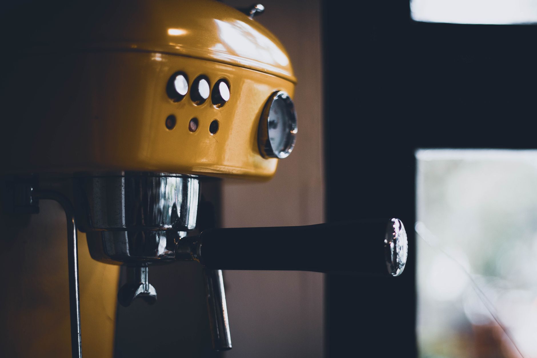 A barista pulling a shot on a vintage lever espresso machine