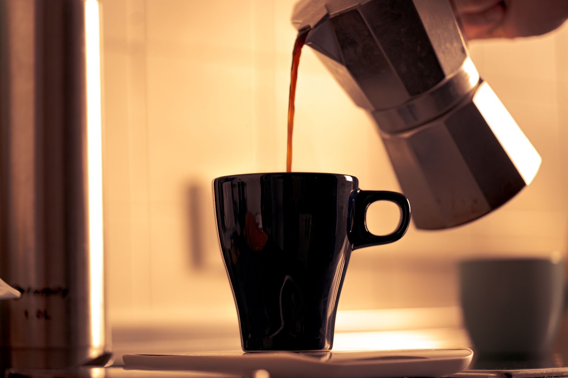 A classic aluminum moka pot brewing on a gas stovetop